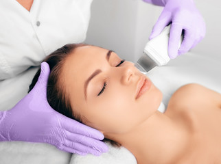 Obraz na płótnie Canvas Beautiful woman receiving ultrasound cavitation facial peeling. Cosmetology and facial skin care
