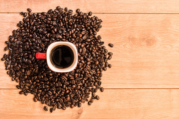 Coffee cup and coffee beans on wooden