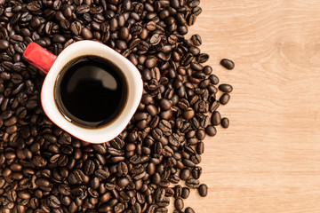 Coffee cup and coffee beans on wooden