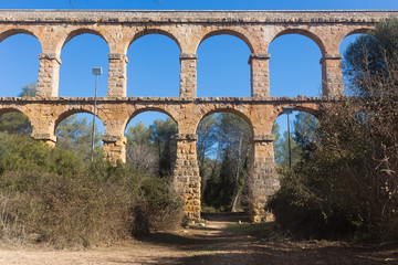 Roman aqueduct in city of Taragona in summer