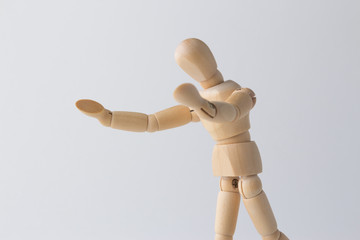 wooden figure doll looking at ground with open arms