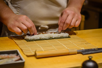 Japanese chef cutting raw fish for sashimi and making sushi