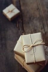 Simple eco friendly gift boxes package wrap with brown paper on wooden table with garden...