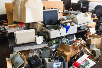 A messy desktop with stacks of files and other documents, all kind of office supplies and part of a...