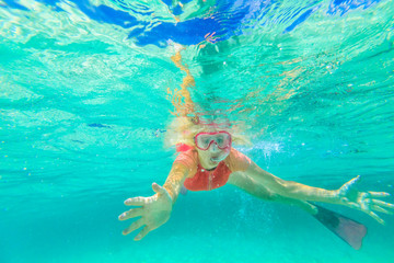 Woman snorkeler swims in a calm natural pool of Denmark Region, Western Australia. Female apnea with pink snorkeling wetsuit. Watersport activity in Greens Pool, William Bay NP. Australian summer
