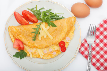 Top view of omelette stuffed with ham and cheese. Omlet breakfast on white background.