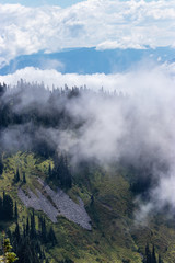 mountain range and valley as seen from high up on a mountain side with clouds
