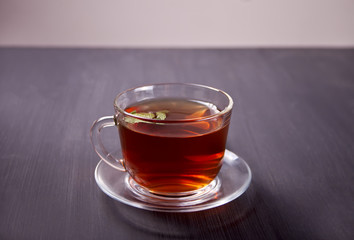 Cup of mint tea on a wooden background.