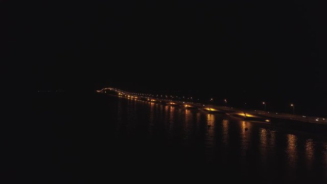 aerial view lighted bridge at night with highways and cars. suspension bridge over madura strait with highway and car, surabaya. aerial view bridge Suramadu connecting islands Java and Madura. High