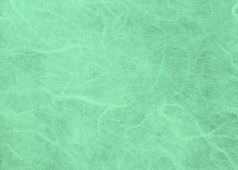 Green handmade mulberry paper texture background.Natural rough rice craft sheet textured pattern close up.Selective focus.