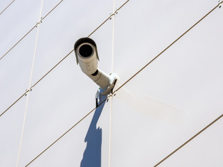 Surveillance camera mounted on a wall lined with ceramic tiles