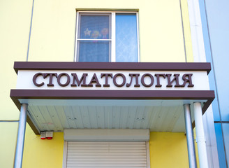 Sign "Dentistry" on the facade of the building