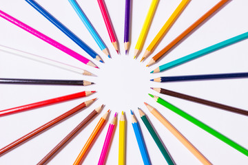 Цветные карандаши лежат вокруг круга.