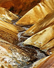 Strongly structured landscape in ocher and brown tones with a small river - Location: Iceland,...