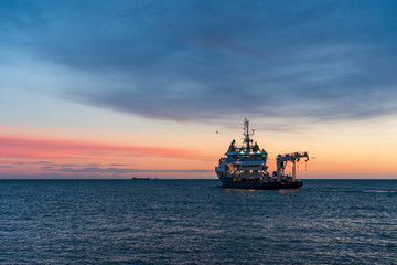 Buoy-Laying Vessel departing from Dun Laoghaire harbor at sunrise in Dublin, Ireland. Seascape with...