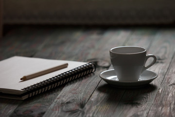 A cup of coffee in the workplace on a wooden table.