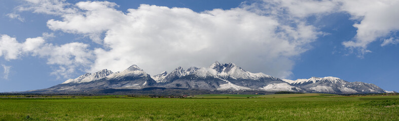 Obraz premium Extra wide panorama of High Tatra mountains during April with snowy hills Vysoke Tatry Slovakia