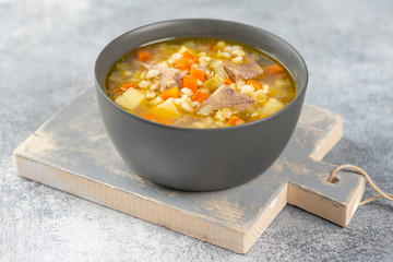 Rassolnik - Traditional Russian soup with pickled cucmbers, pearl barley, meat, pickles, carrots and potatoes  on light background. Top view