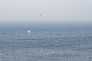Sea scape with foggy atmosphere and sailing boat