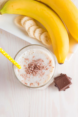 Fresh Made Chocolate Banana Smoothie on a wooden table. Selective focus. Milkshake with almonds. Protein diet. Healthy food and drink concept.