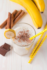 Fresh Made Chocolate Banana Smoothie on a wooden table. Selective focus. Milkshake with almonds. Protein diet. Healthy food and drink concept.