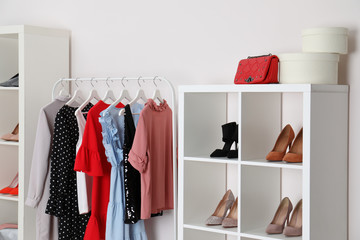 Wardrobe shelves with different stylish shoes and clothes indoors. Idea for interior design