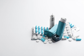 Asthma inhalers, pills and space for text on white background