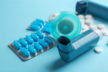 Set of asthma medications on color background