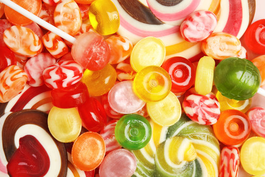 Different delicious colorful candies as background, top view