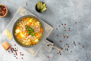 Rassolnik - Traditional Russian soup with pickled cucmbers, pearl barley, meat, pickles, carrots and potatoes  on light background. Top view