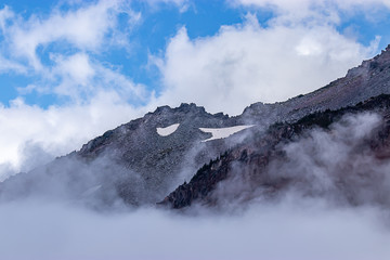 Fototapeta na wymiar harsh craggy mountaintop with clouds and fog