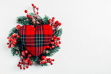 Christmas decorative wreath of holly, ivy, mistletoe, cedar and leyland leaf sprigs with red berries over white background.