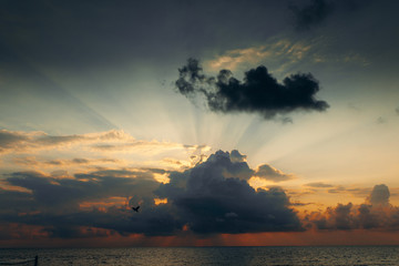 Sunset with clouds, light rays and other atmospheric effect. Dramatic cloudy skyline