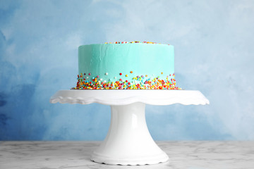 Fresh delicious birthday cake on stand against color background
