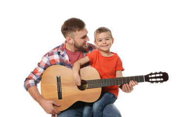 Father teaching his little son to play guitar on white background