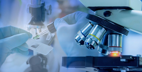  Close up shot of microscope equipment with metal lens in laboratory. Researcher hands in rubber...