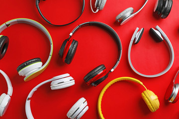Many different headphones on color background, top view
