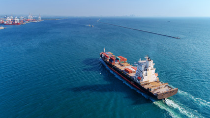 Aerial view container ship going to sea port for import export, shipping or transportation concept background.