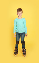 Full length portrait of boy with inline roller skates on color background