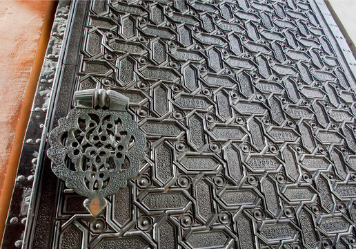 Metal door with islamic patterns and Arabic calligraphy of the 16th centure Seville Cathedral, Spain. Motifs in artworks of Andalusia
