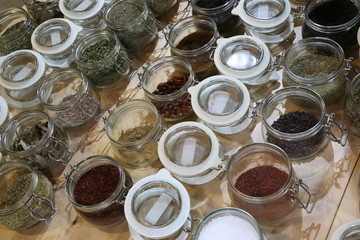 many glass trays with spices and herbs from around the world