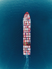 Aerial top view container ship on the sea full load container for import export, shipping or transportation.