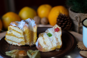 View of Christmas decor. Christmas objects: dried sliced orange, cinnamon, pine cone, fir branch, cup coffee, cheesecake, walnut, golden Christmas bells.