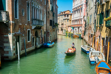 Fototapeta na wymiar Venice, Italy, August 14, 2018: Gondolas on the canal in Venice