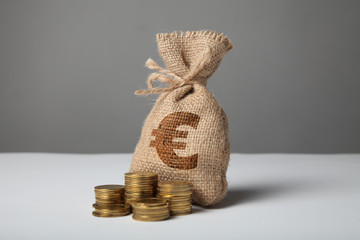 Sack with money and euro silhouette on gray background. Symbol of wealth and high profits.