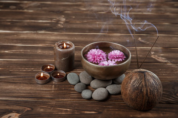 Singing bowl with candles with pebbles on dark wooden background
