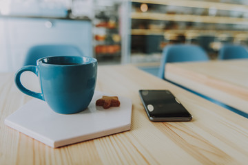 Selective focus of a blue coffee cup on the table