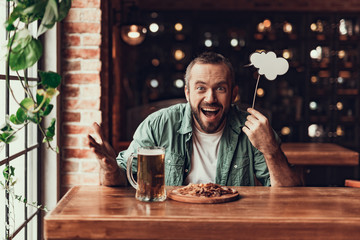 Cheerful bearded man with speech bubble spending time at pub
