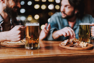 Friends enjoying drinks and snacks while spending time at pub