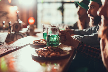 Friends drinking beer while sitting at bar counter